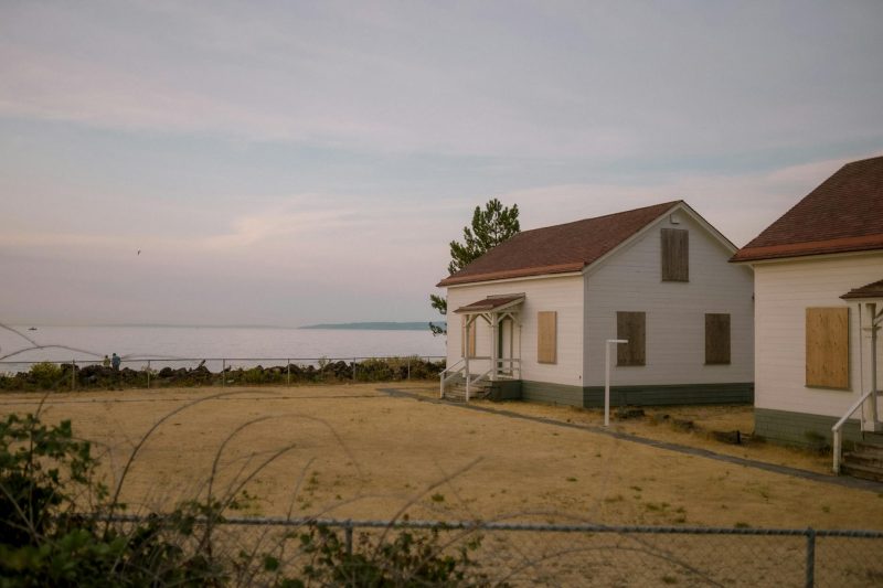 Abandoned cottages on Seattle's coastline, set against a tranquil dusk sky.