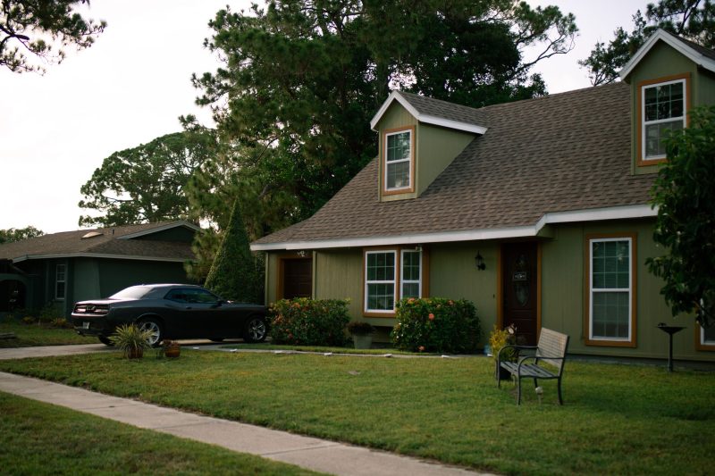 Beautiful suburban home with a green lawn and parked car, showcasing residential comfort.