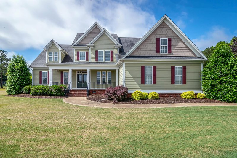 Beautiful two-story suburban house with a manicured lawn and a welcoming front porch.
