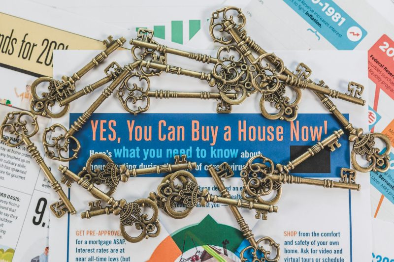 Vintage keys resting on real estate documents, symbolizing property ownership and investment.